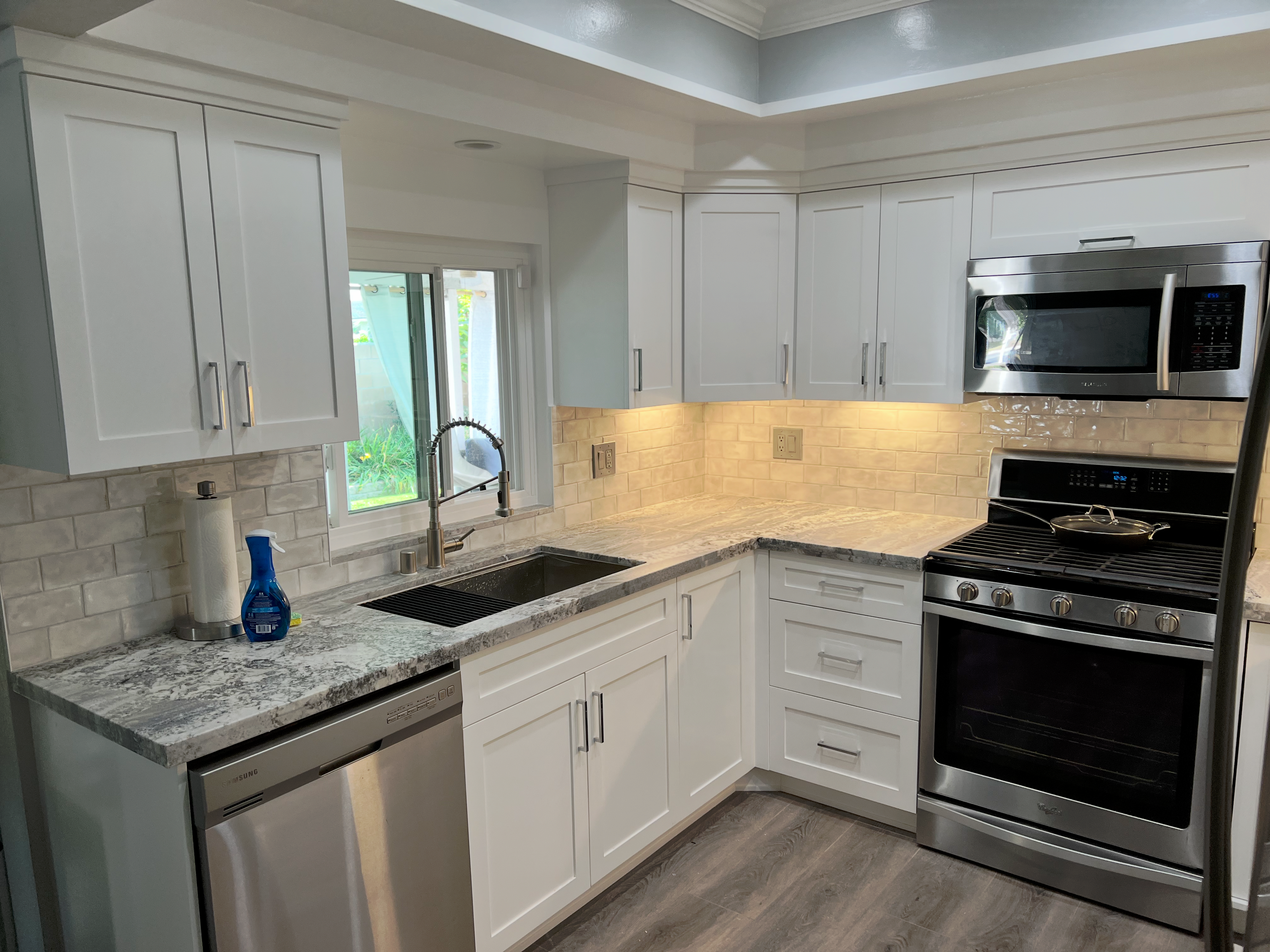 Completed kitchen remodel with white shaker cabinets and granite countertops